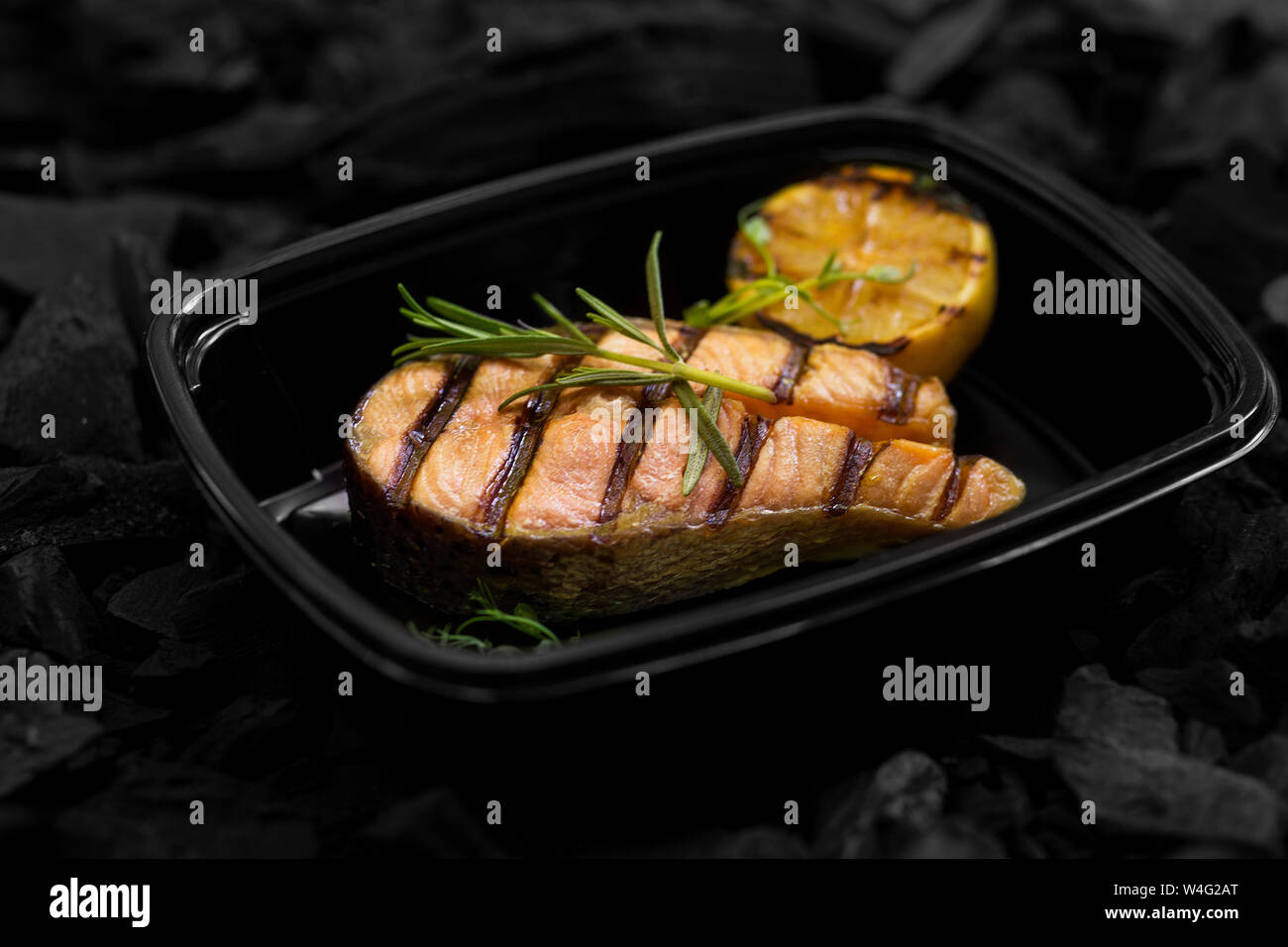Close up di fresco pesce cucinato con rosmarino nella casella Foto Stock