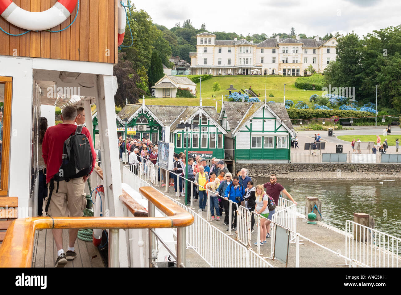 Bowness on Windermere - MV Teal incrociatore vapore arrivando a Bowness Pier e i passeggeri in coda sul molo a bordo - Lake District, Cumbria, England, Regno Unito Foto Stock