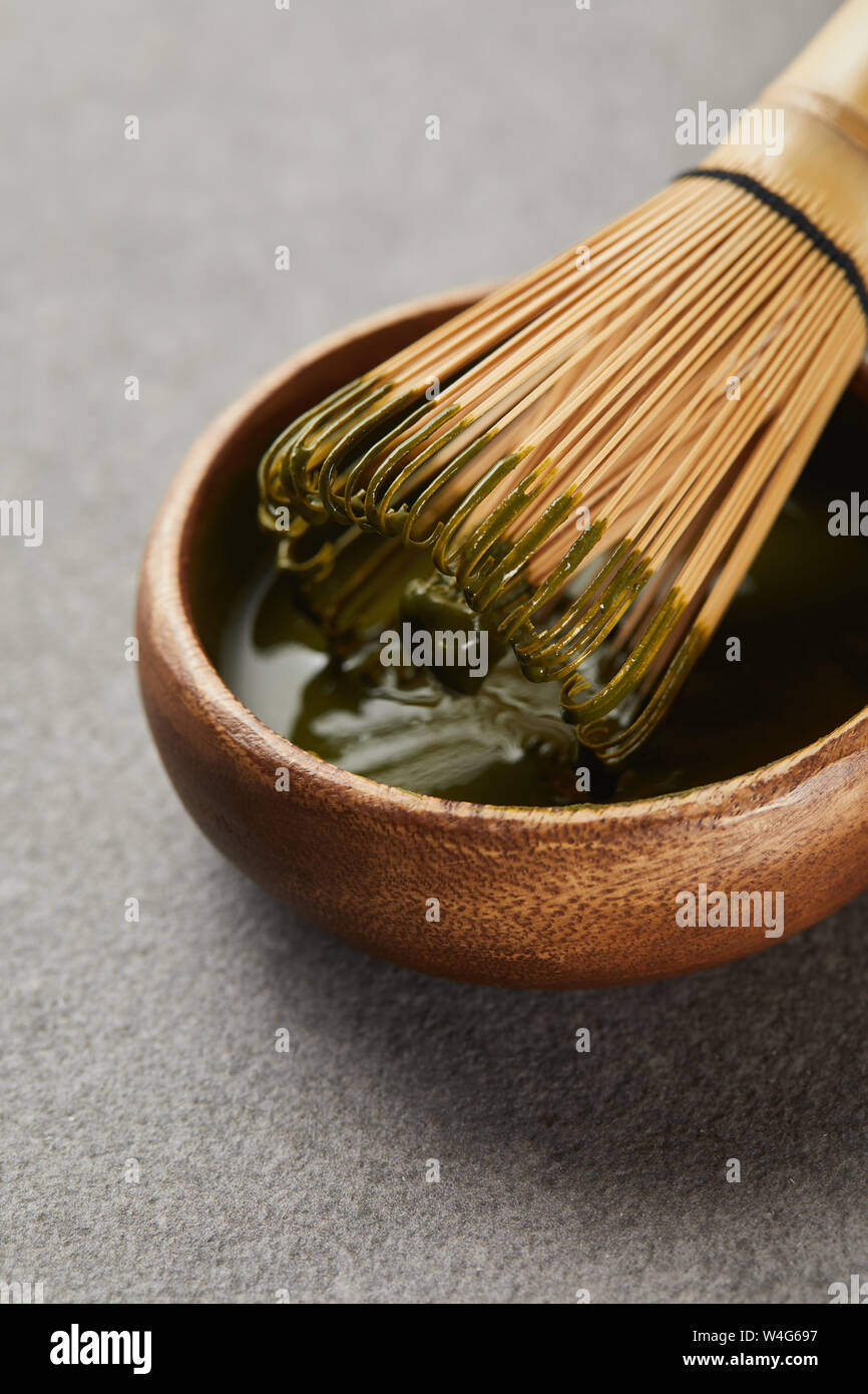 Frusta di bambù nella ciotola di legno con matcha tea Foto Stock