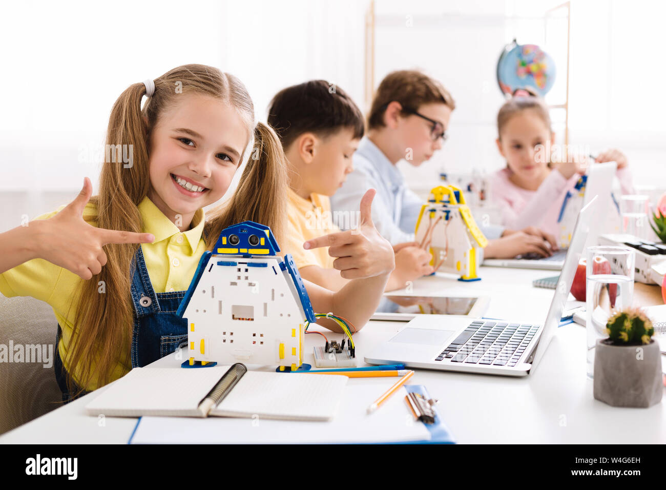 Ragazza che mostra il suo robot. Studente orgoglioso del suo progetto Foto Stock