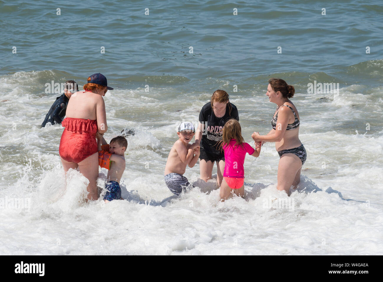 Martedì 23 luglio 2019. Aberystwyth Wales UK UK meteo: persone al mare in Aberystwyth godendo di una torrida estate nel pomeriggio in un giorno di ininterrotta in un cielo azzurro e sole caldo. Il paese sta vivendo il giorno più caldo dell'anno finora come un pennacchio di scorching aria calda derive dal continente. Credito foto Keith Morris / Alamy Live News Foto Stock