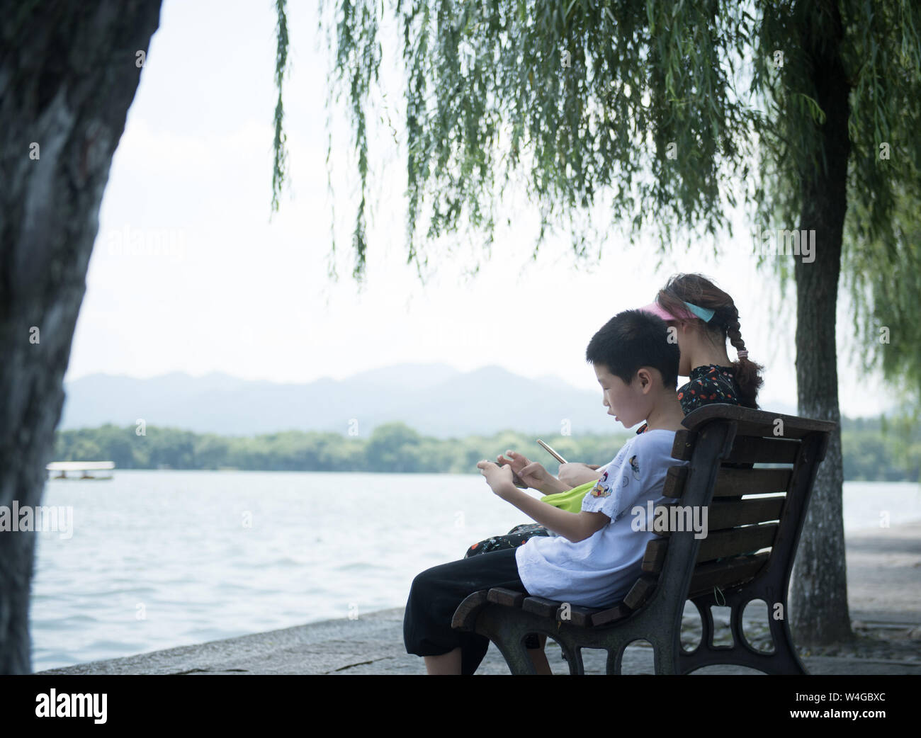 (190723) -- HANGZHOU, luglio 23, 2019 (Xinhua) -- i turisti resto vicino al West Lake in Hangzhou, est della Cina di Provincia dello Zhejiang, 23 luglio, 2019. Onda di Calore continua a colpire Hangzhou fino ai primi di agosto. (Xinhua/Weng Xinyang) Foto Stock