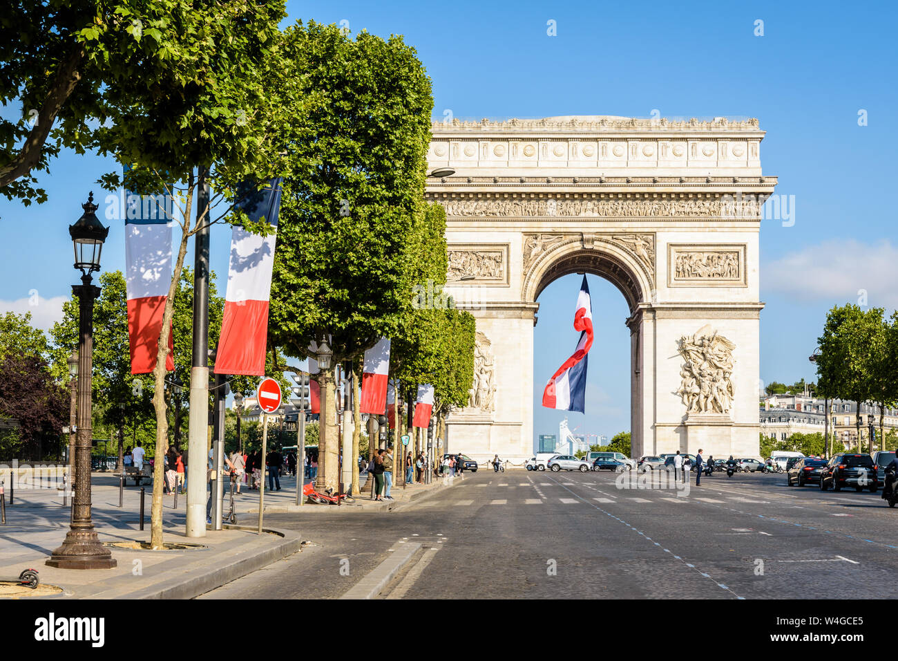 Per il giorno della Bastiglia una grande bandiera francese vola sotto l'Arc de Triomphe in Parigi, Francia e la Avenue des Champs Elysees è adornato con bandiere francesi. Foto Stock