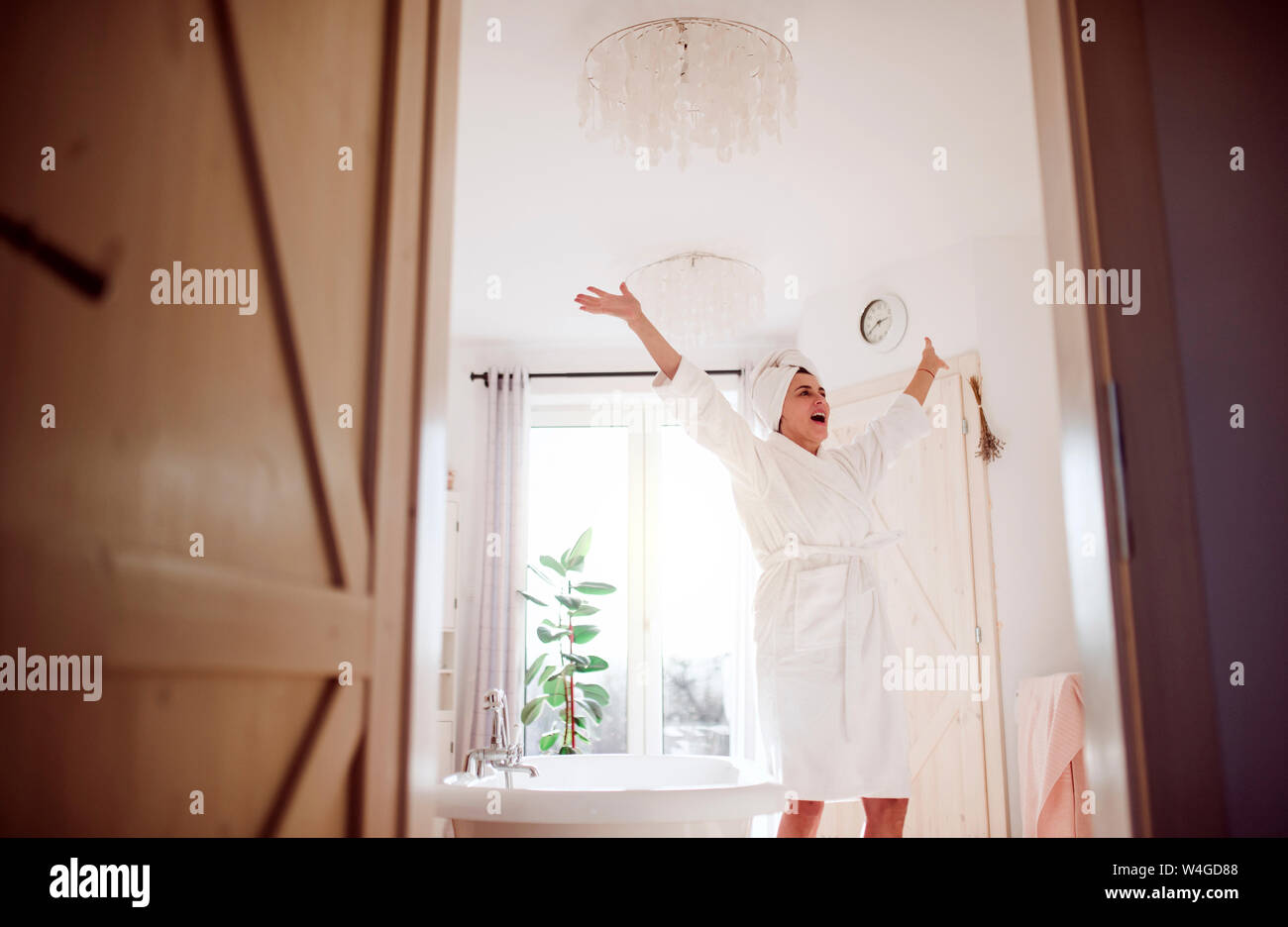 Felice donna matura in un bagno a casa Foto Stock