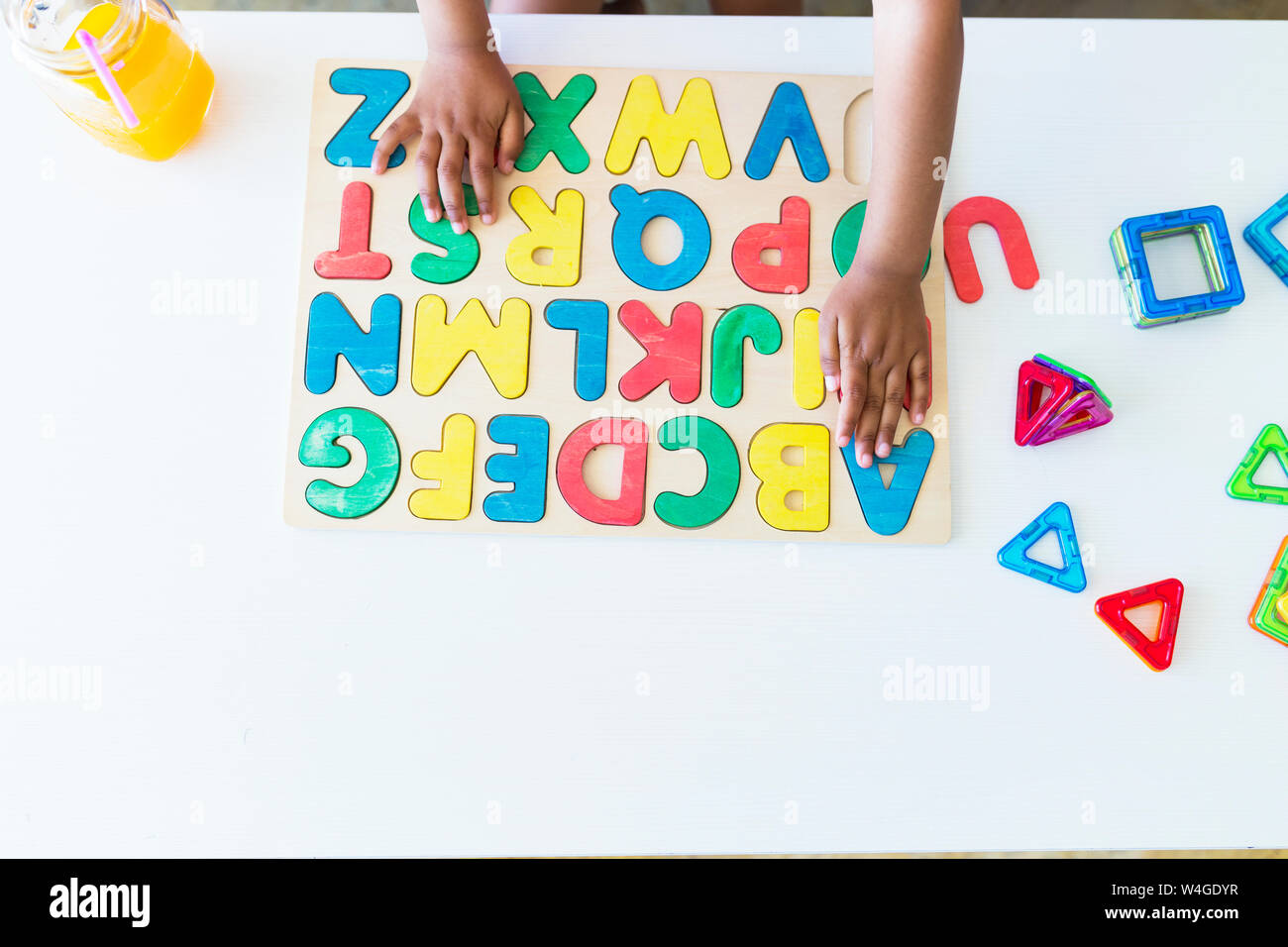 Close-up della ragazza che gioca con alfabeto gioco di apprendimento sul tavolo Foto Stock