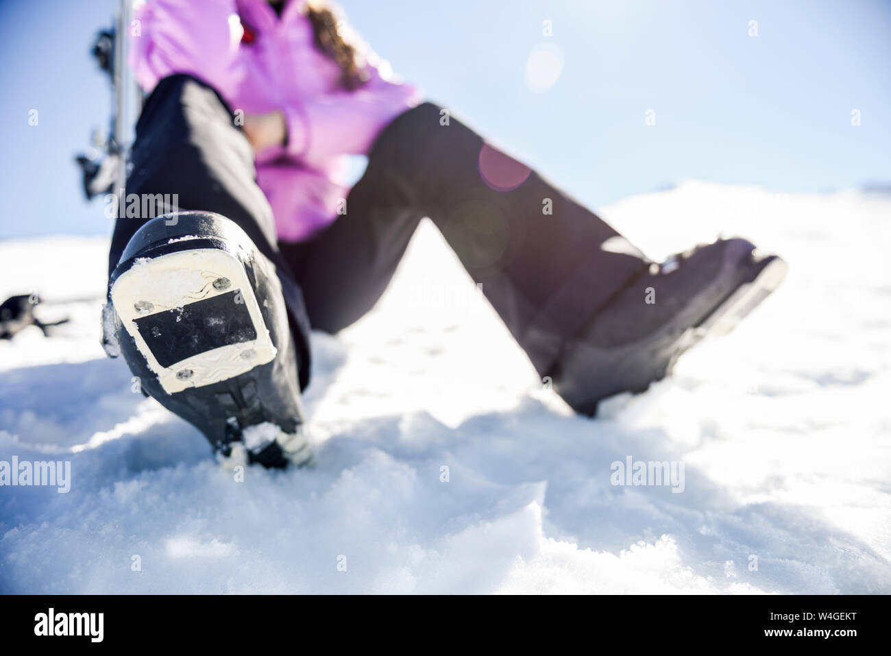 Close-up di donna prendendo una pausa dopo lo sci di seduta sul terreno innevato in Sierra Nevada, Andalusia, Spagna Foto Stock