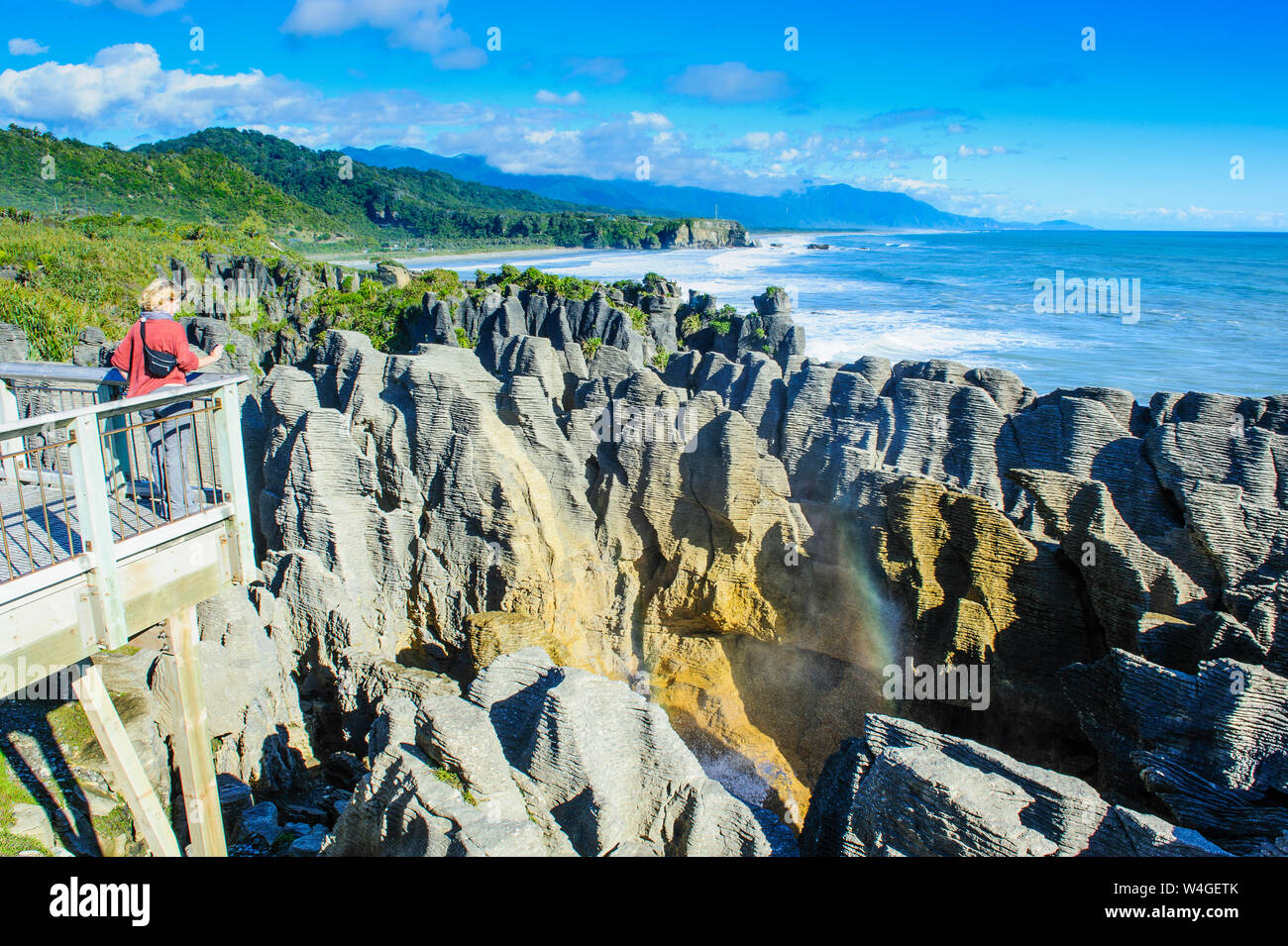 Donna sulla piattaforma di osservazione a Pancake Rocks, Paparoa National Park, Isola del Sud, Nuova Zelanda Foto Stock
