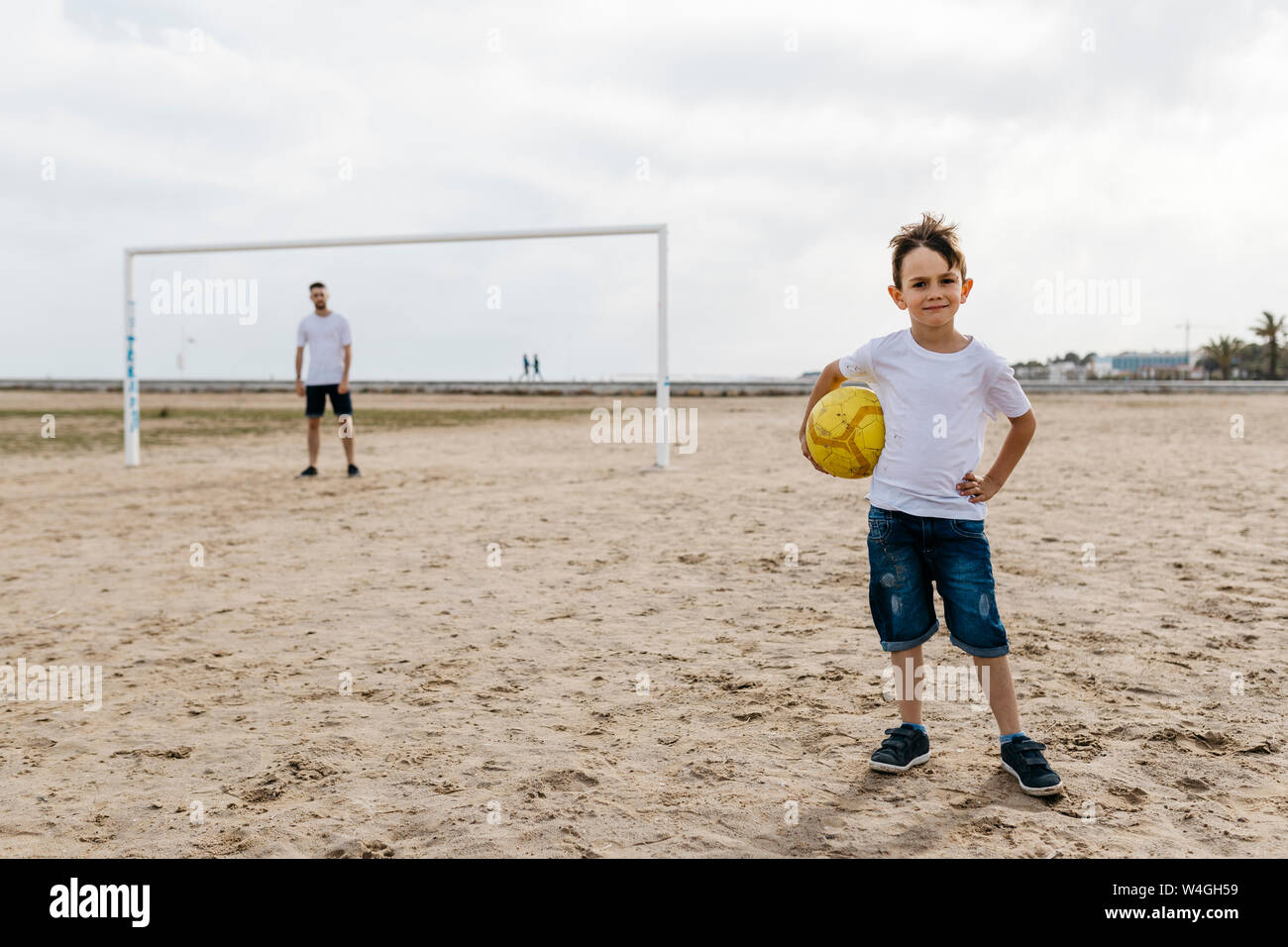 Ritratto di ragazzo con calcio sulla spiaggia Foto Stock