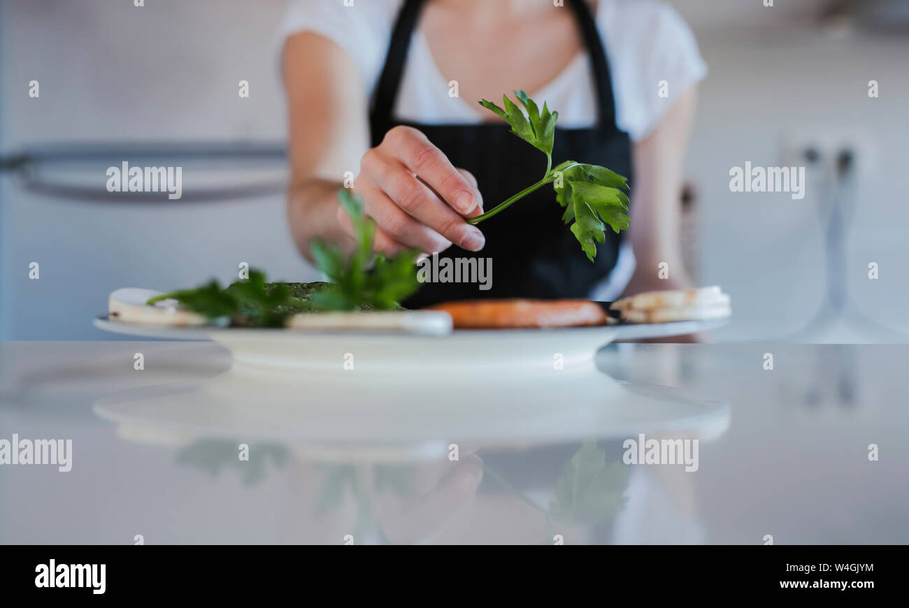 Giovane donna la mano della piastra di farcitura con cibo vegetariano, close-up Foto Stock
