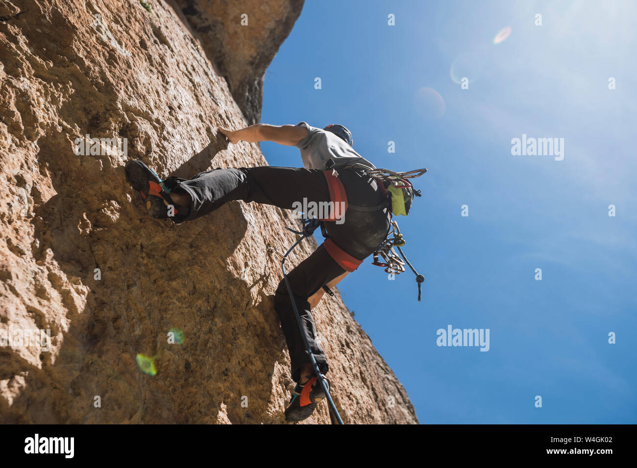 Uomo di arrampicata in parete di roccia Foto Stock