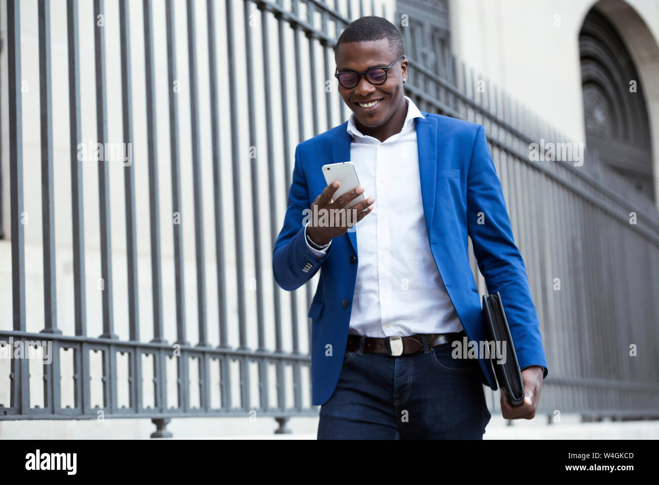 Giovane imprenditore indossare tuta blu camicia e utilizza lo smartphone Foto Stock