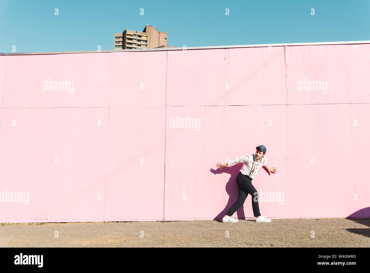 Giovane uomo nella parte anteriore della struttura rosa barriera, traying per sfuggire Foto Stock