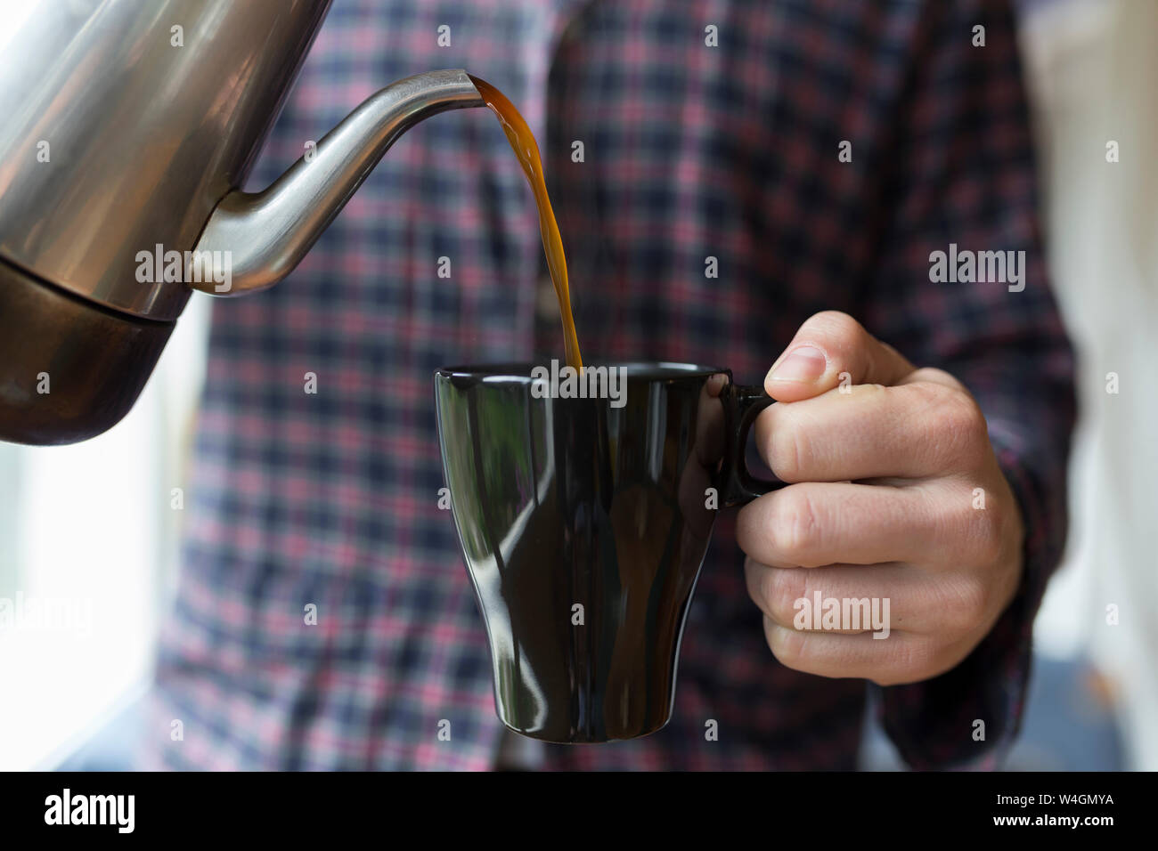 L'uomo versando il caffè in una tazza Foto Stock