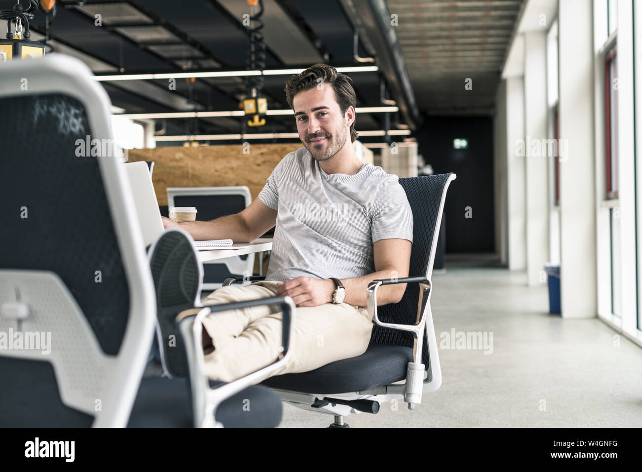 Giovane imprenditore lavora rilassato in un ufficio moderno Foto Stock