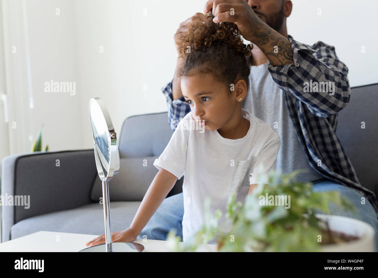 Padre figlia facendo i capelli sul lettino a casa Foto Stock