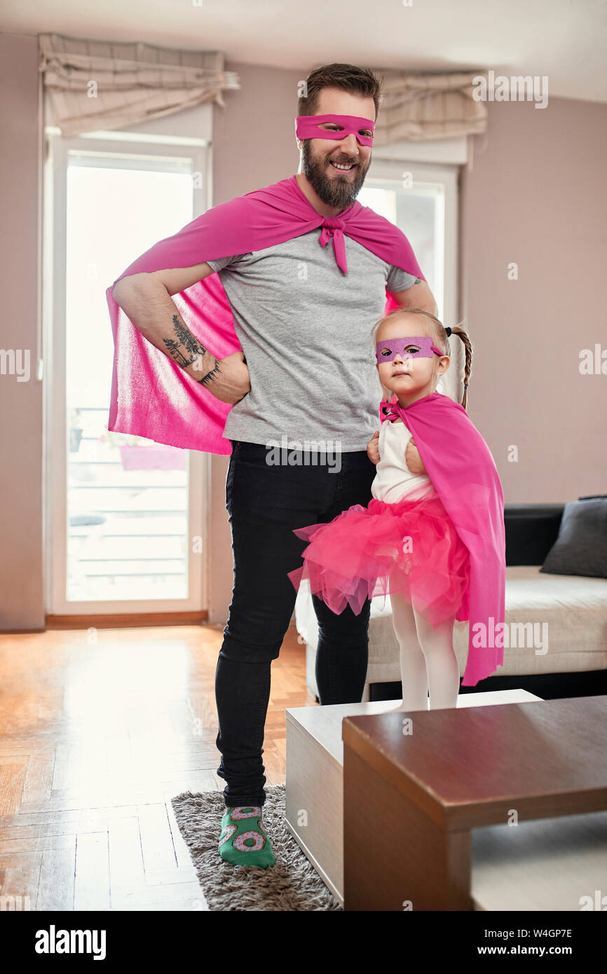 Padre e figlia gioca supereroe e superwoman Foto Stock