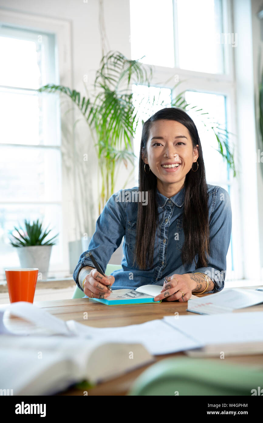 Ritratto di donna felice lavorando a tavola in office Foto Stock