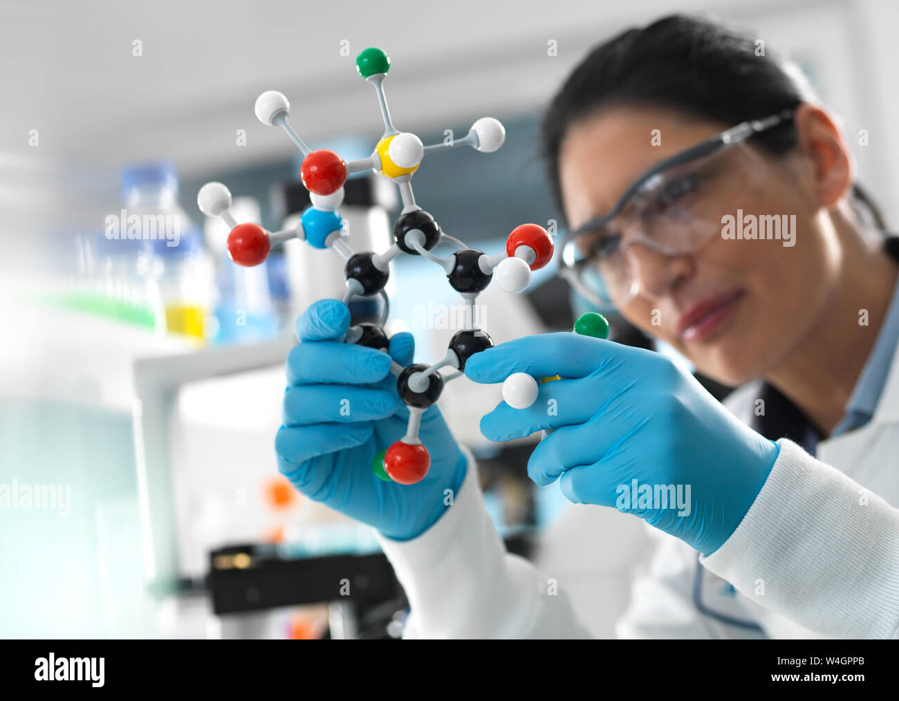 Ricerca biotecnologica, scienziato esaminando una palla e stick modello molecolare di una formula chimica durante un esperimento Foto Stock