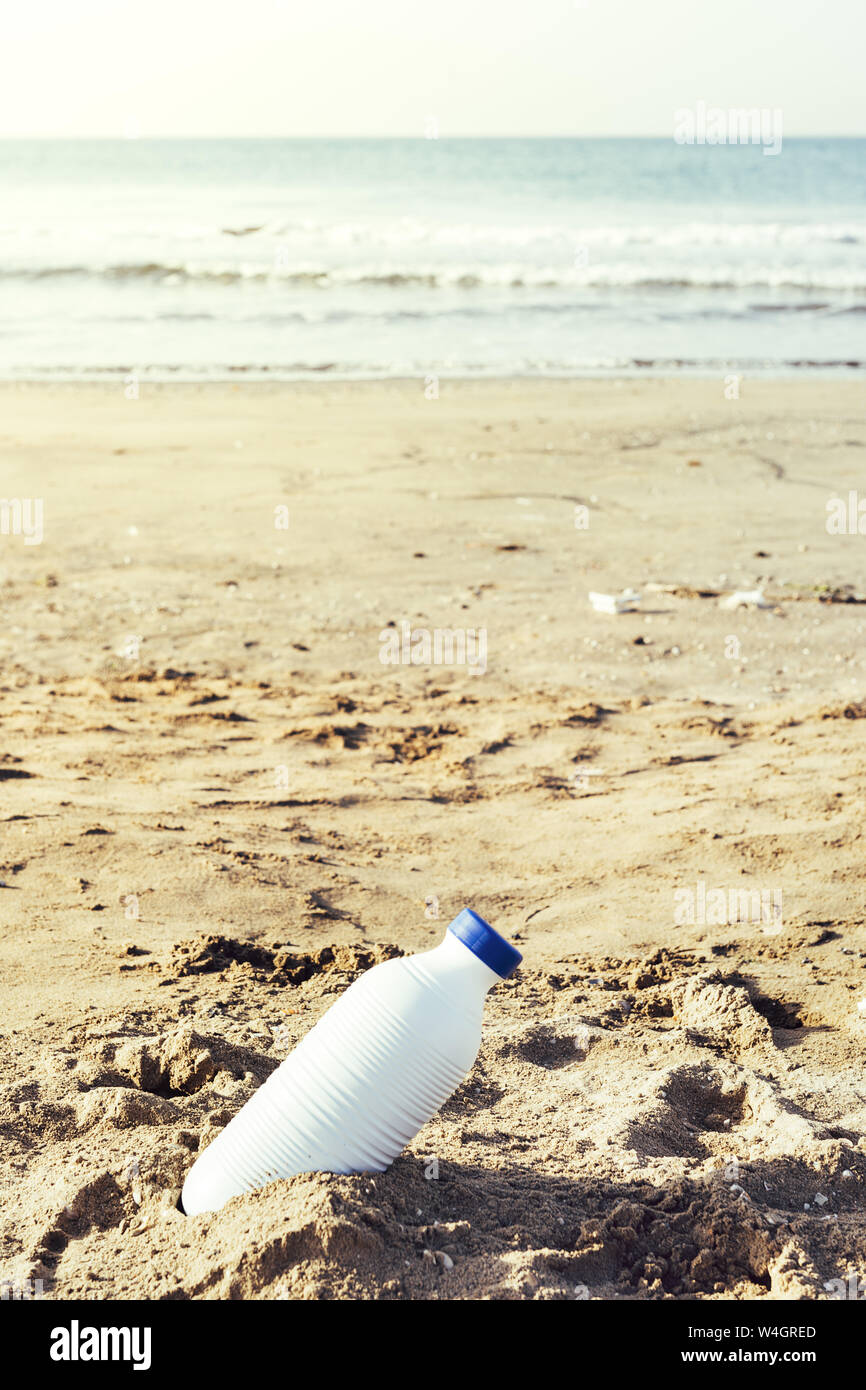 Foto verticale di una bottiglia di plastica bianca distesi sulla sabbia  della spiaggia e inquina il mare e la vita marina, il concetto di controllo  dell inquinamento del Foto stock - Alamy