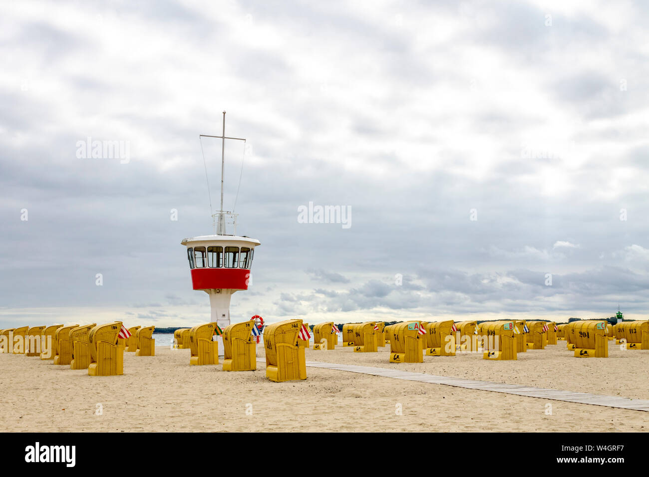 Vista della spiaggia con incappucciati sdraio in spiaggia e dell'assistente di tower, Lubecca Travemuende, Germania Foto Stock