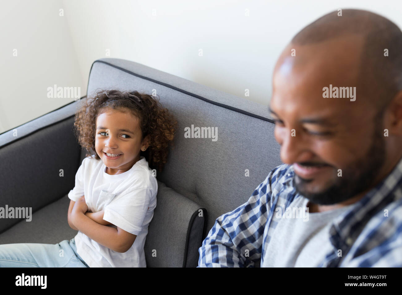 Felice padre e figlia seduti sul divano di casa Foto Stock