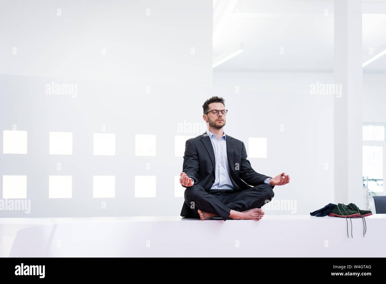 Imprenditore fare yoga in ufficio Foto Stock