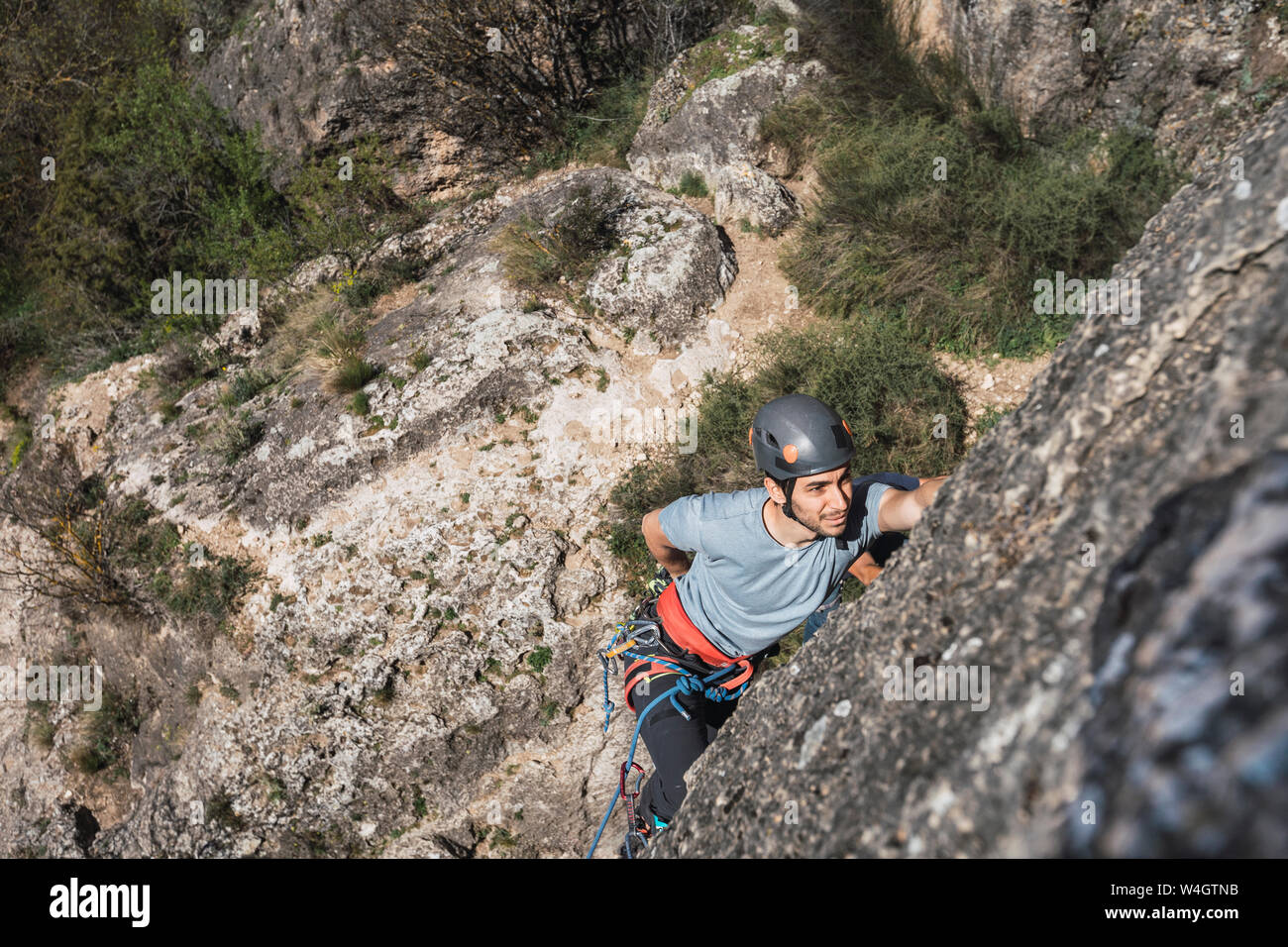 Uomo di arrampicata in parete di roccia Foto Stock