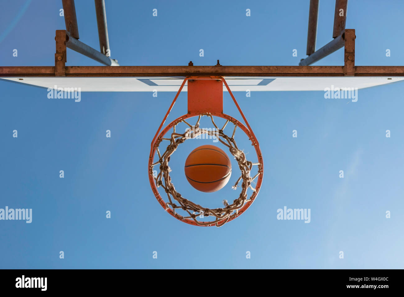 La pallacanestro e hoop, cielo blu, vista verso l'alto Foto Stock