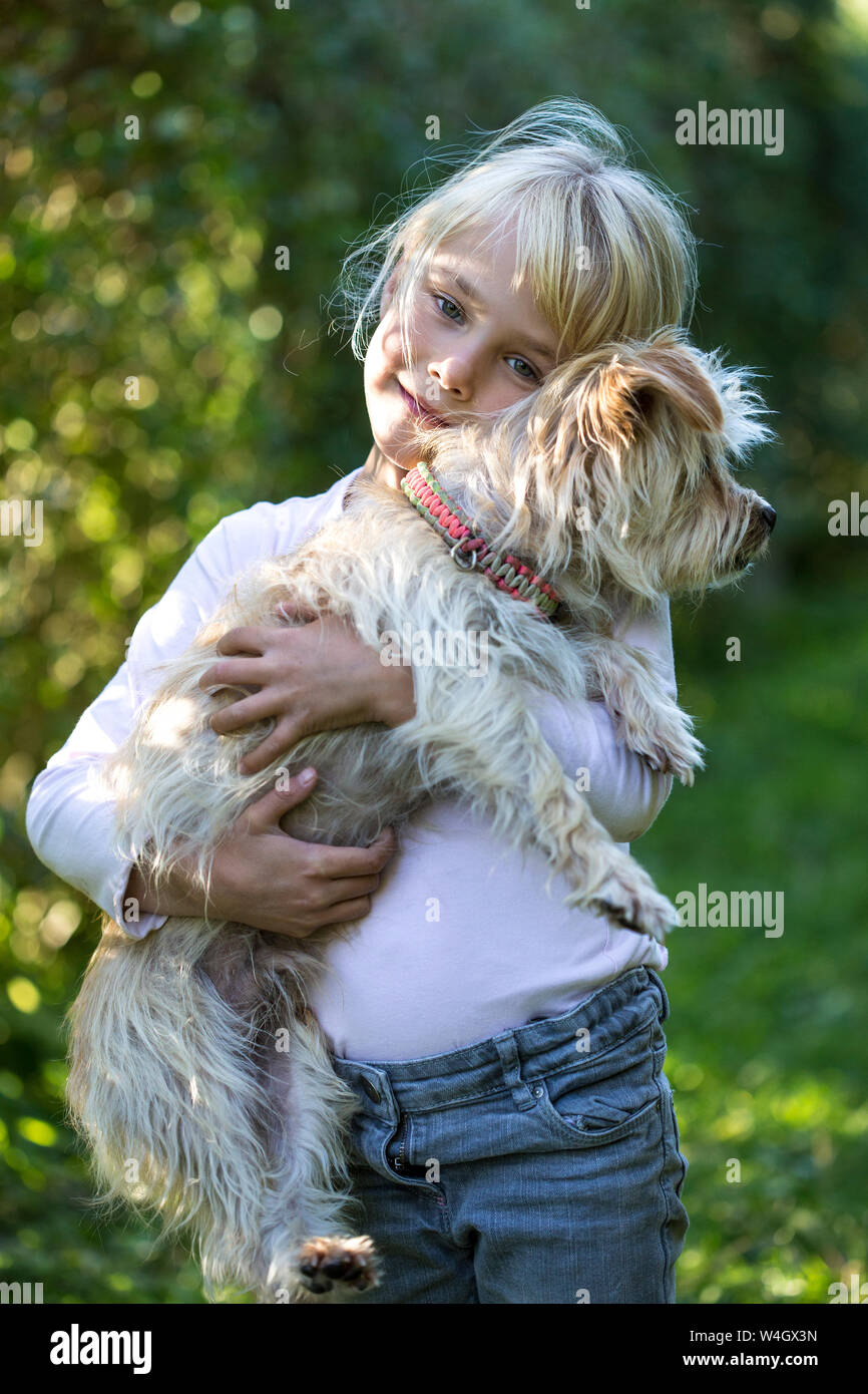 Ritratto di felice bambina con il suo cane in giardino Foto Stock
