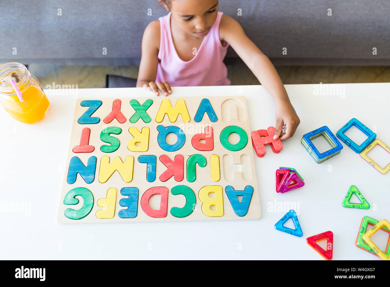 Ragazza che gioca con alfabeto gioco di apprendimento a casa Foto Stock
