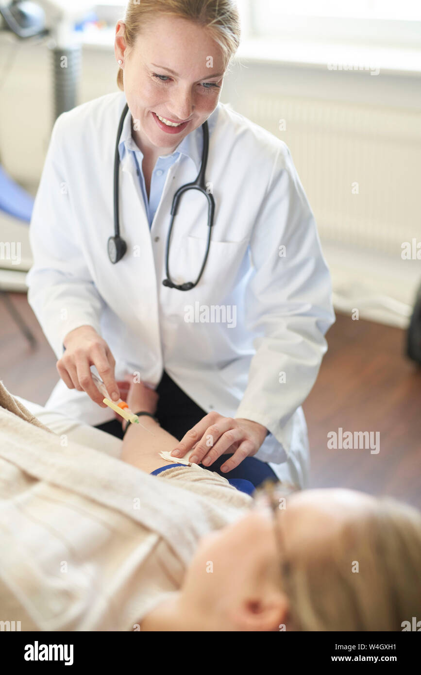 Medico donna prendendo un campione di sangue dal paziente nella pratica medica Foto Stock