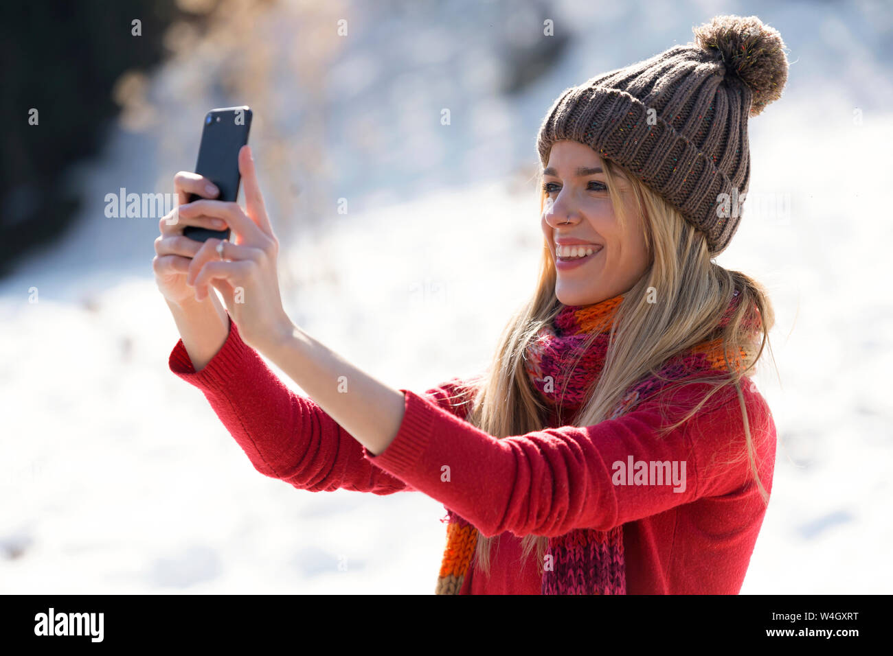 Giovane donna bionda prendendo un selfie in inverno Foto Stock