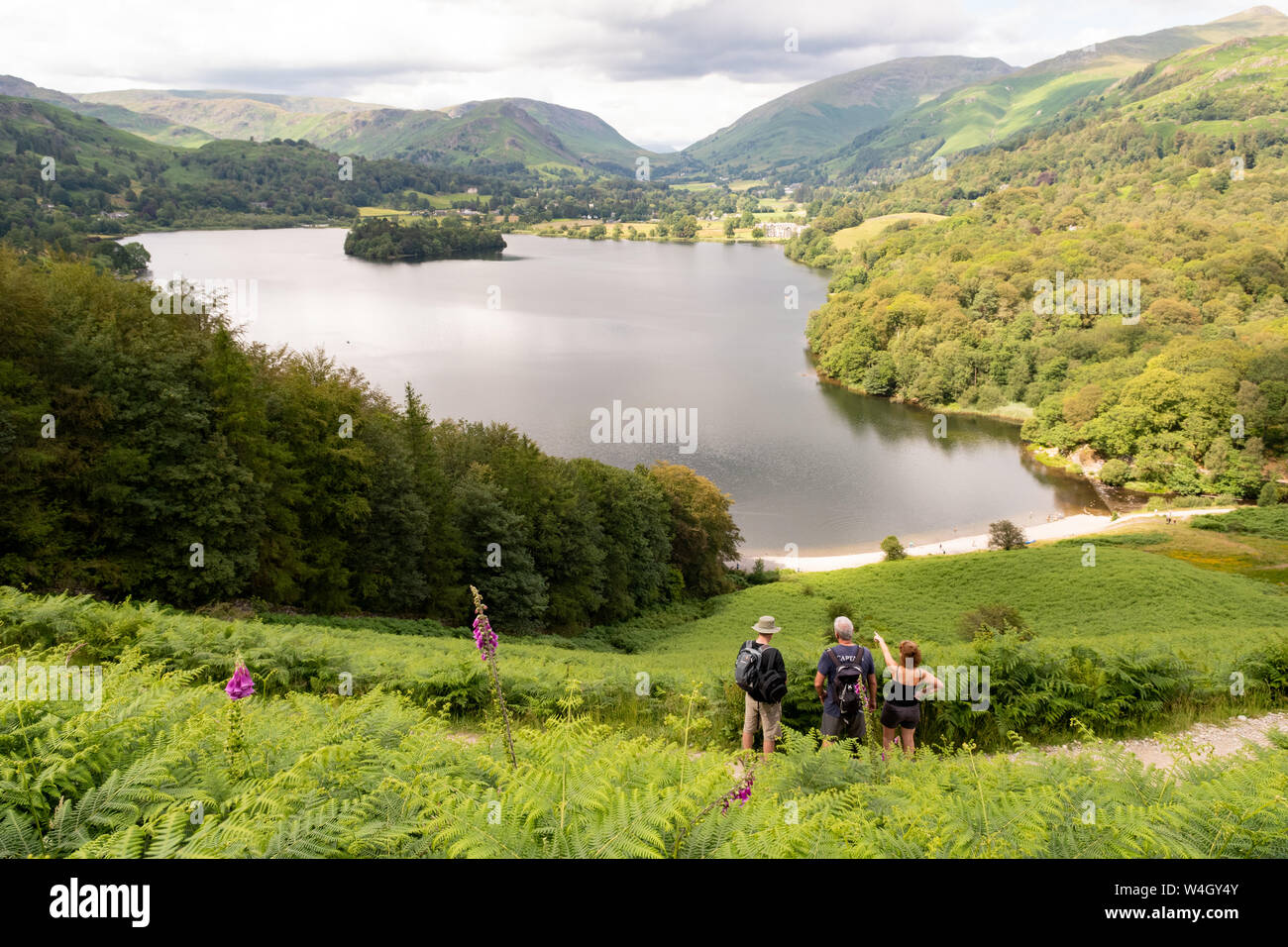 Walkers visualizzazione Grasmere lago dalla terrazza Loughrigg sentiero, guardando verso l'acciaio cadde e sandalo del sedile sul lato di sollevamento Dunmail, Cumbria, Foto Stock