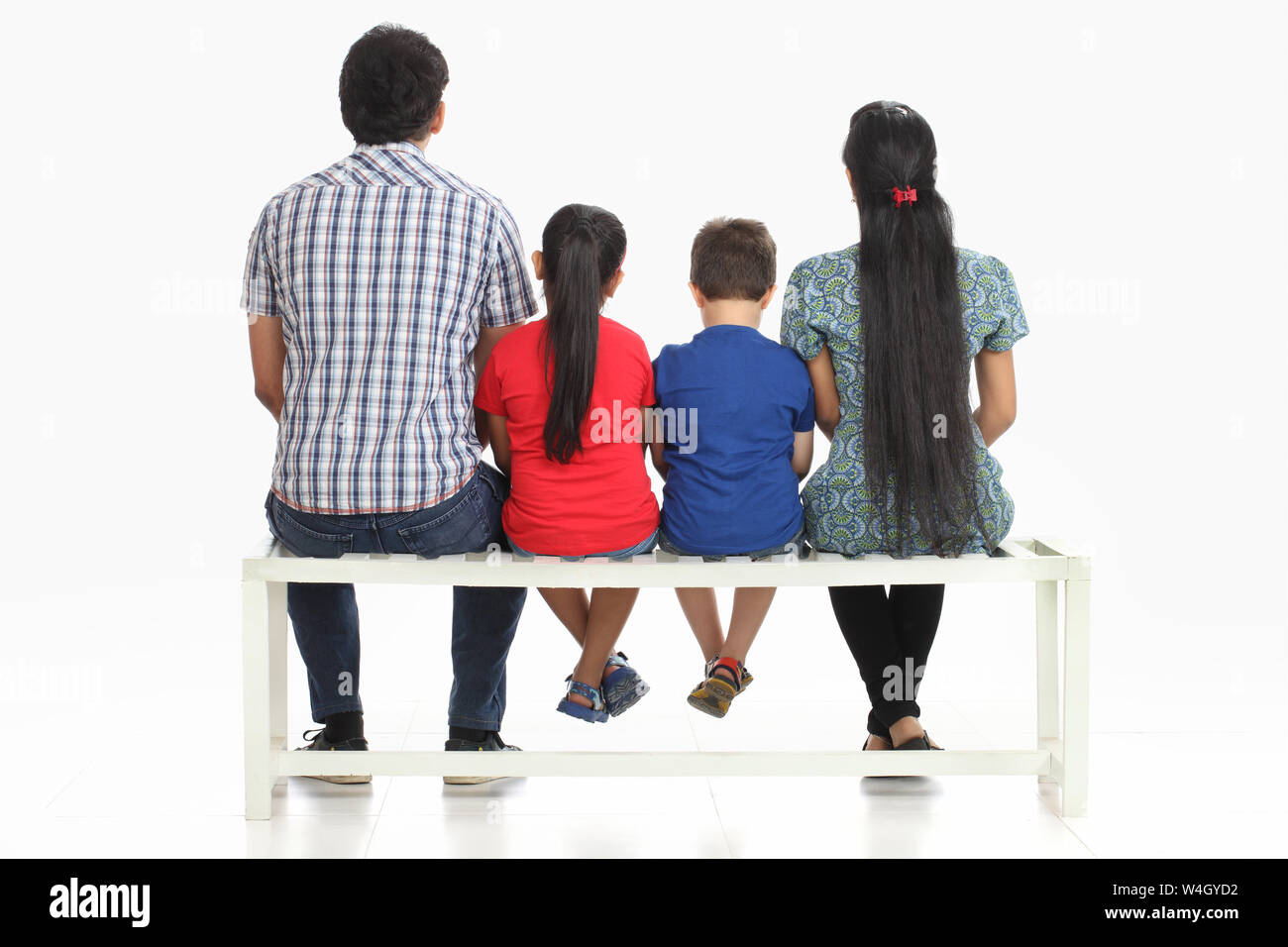 Vista posteriore di una famiglia seduta su una panchina Foto Stock