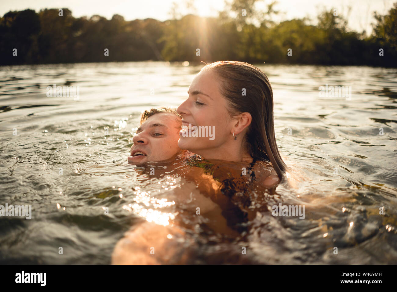 Affettuosa giovane nuoto insieme in un lago Foto Stock