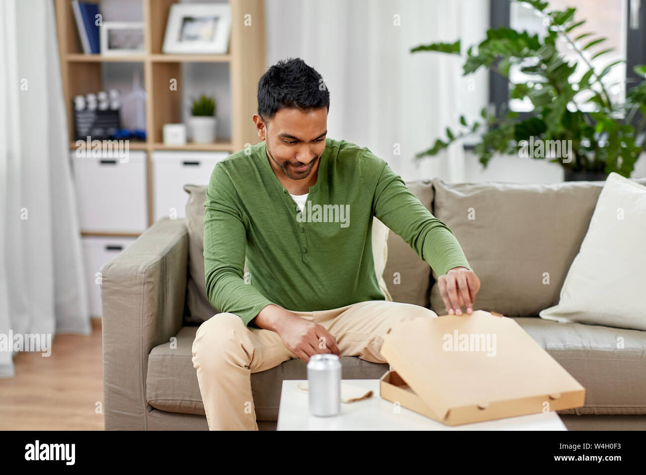 Indian uomo cerca all'interno della pizza da asporto box Foto Stock