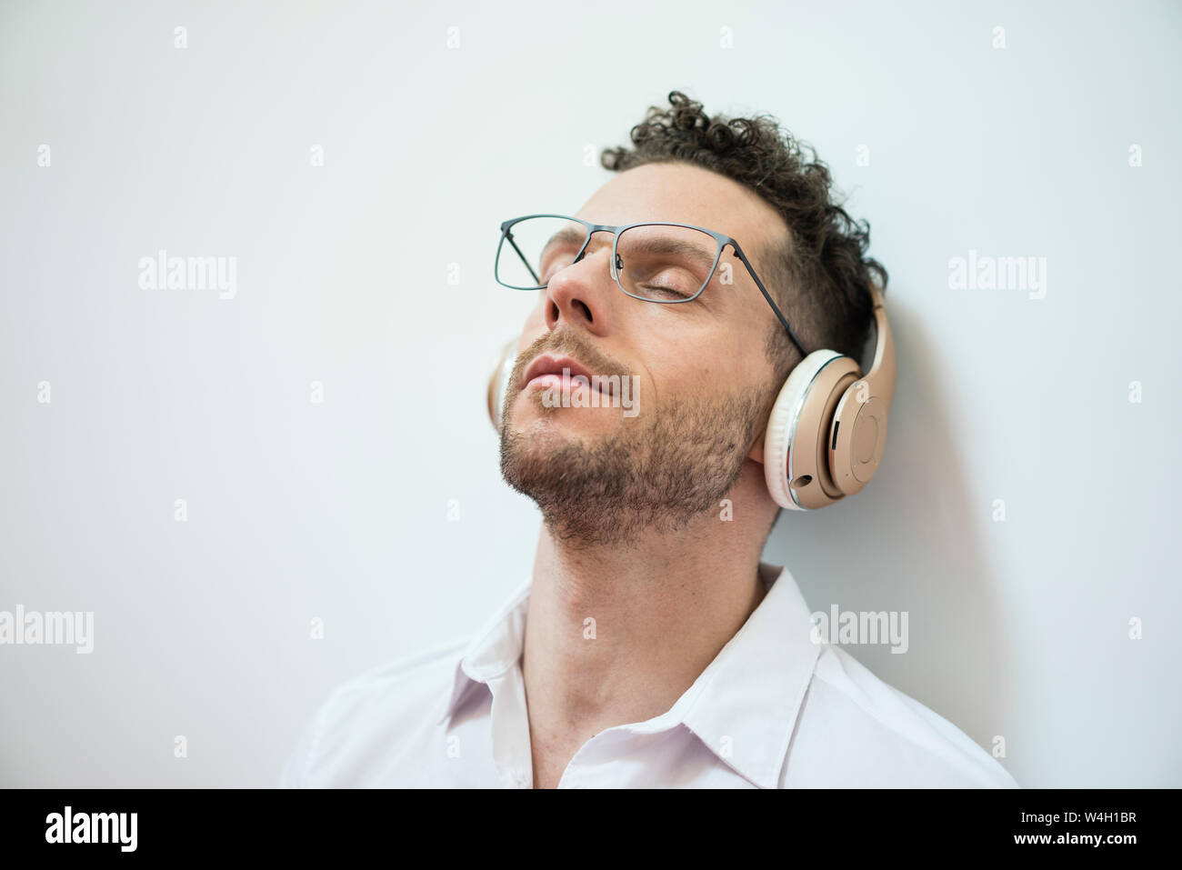 Imprenditore con gli occhi chiusi per ascoltare musica con le cuffie Foto Stock