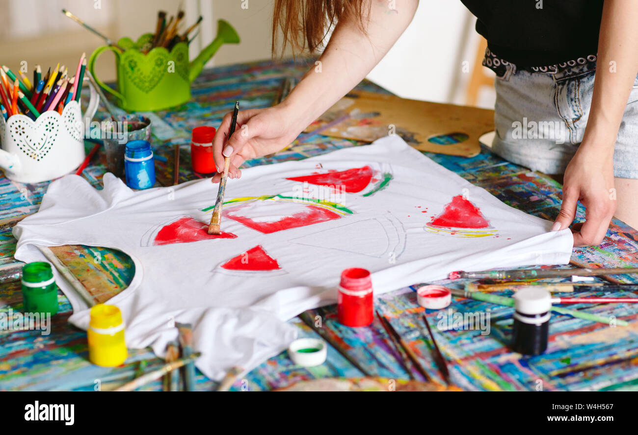 Disegno su vestiti. Ragazza richiama su una T-shirt bianco. Foto Stock
