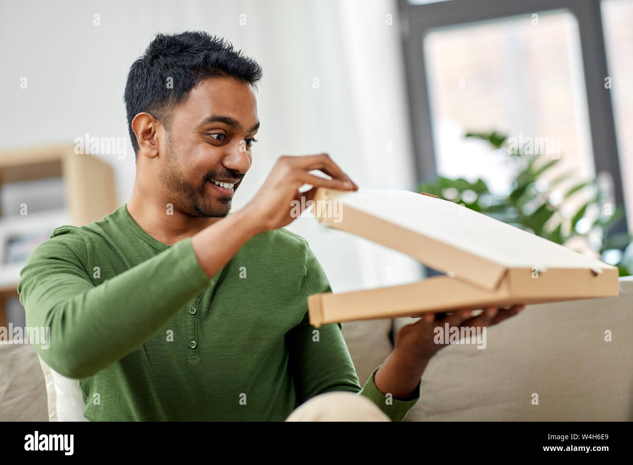 Indian uomo cerca all'interno della pizza da asporto box Foto Stock