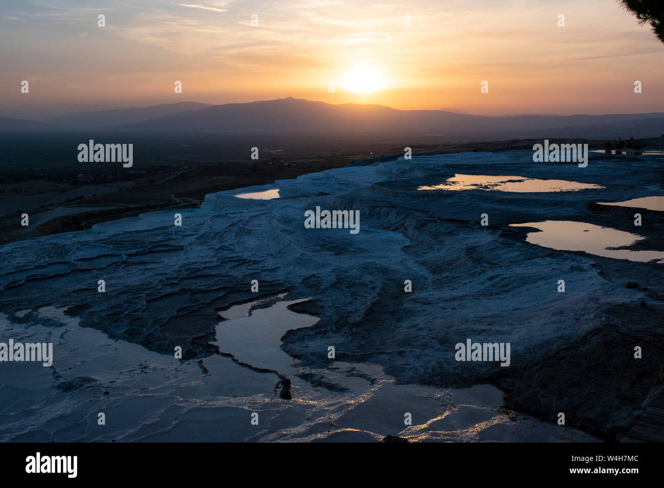 Turchia: tramonto sulle terrazze di travertino di Pamukkale (Castello di cotone), il sito naturale di roccia sedimentaria depositato dall'acqua di sorgenti calde, Foto Stock