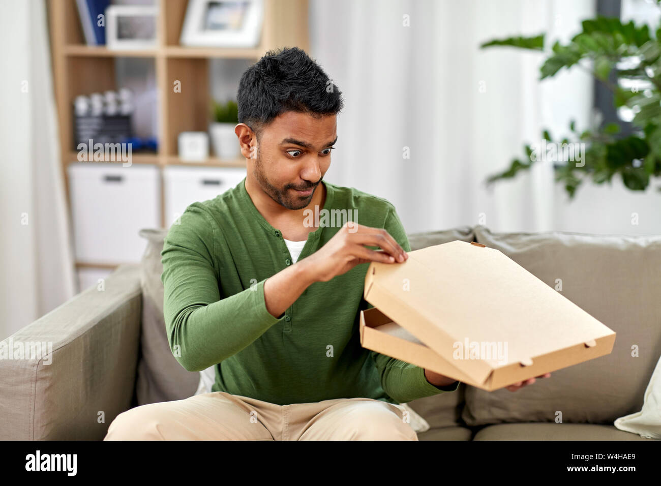 Indian uomo cerca all'interno della pizza da asporto box Foto Stock