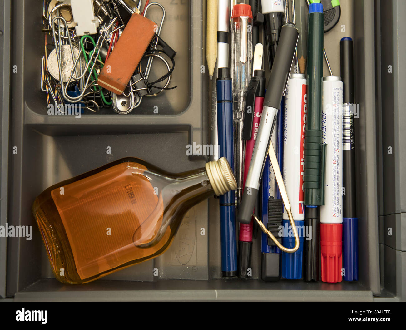 Immagine simbolo della dipendenza, alcolici, liquori, nascosto al lavoro, in ufficio il cassetto, Foto Stock