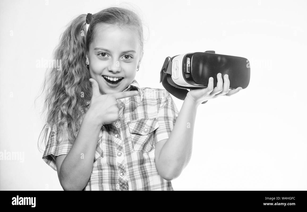 Bambina indossa la realtà virtuale gli occhiali. Bambino in VR auricolare. Futuro digitale e dell'innovazione. Un bambino piccolo in VR senza fili di vetro. Capretto felice utilizzo della tecnologia moderna. È così reale. Il lavoro virtuale. Foto Stock