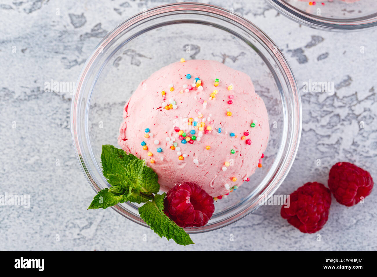 Gelato al lampone sfere con bacche e foglie di menta in ciotole in vetro Foto Stock