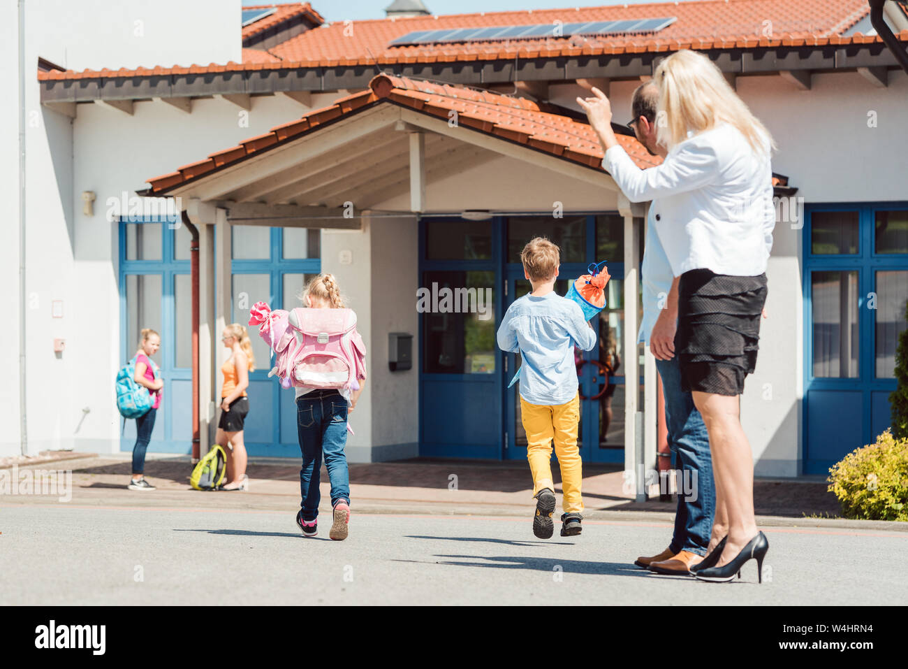 Madre che desiderano la sua figlia una felice giornata a scuola Foto Stock