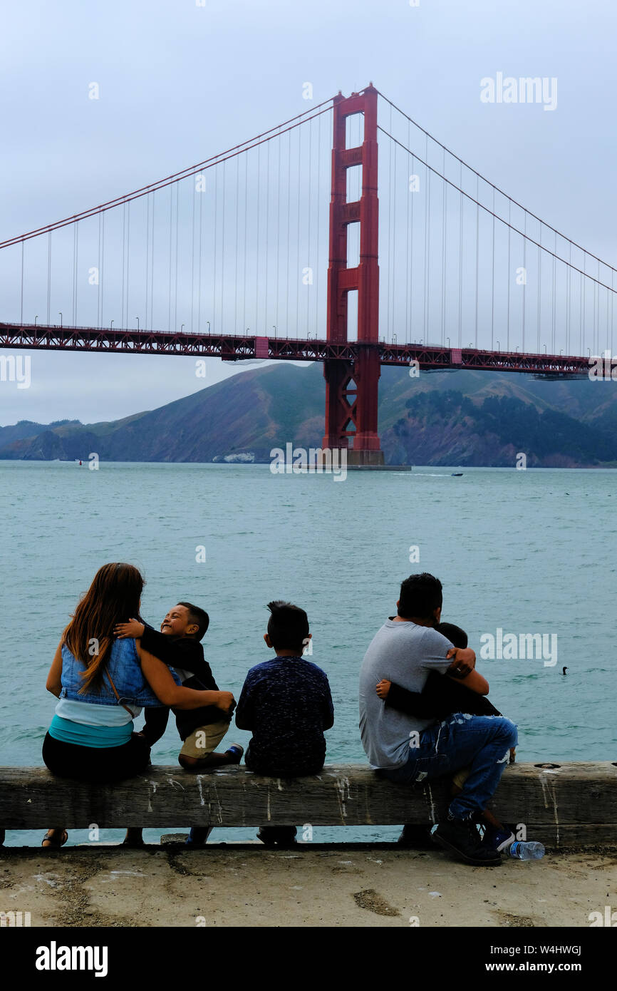 Giovane famiglia ispanica visualizzando il Golden Gate bridge dal siluro Wharf a presidio park di San Francisco, California; Latino unità, amore, tempo per la famiglia Foto Stock
