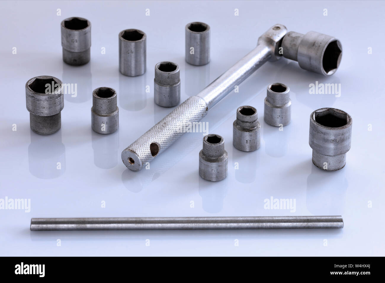 Un set universale di teste con un cricchetto per la vettura in una lucida sfondo grigio chiaro, close-up. Foto Stock