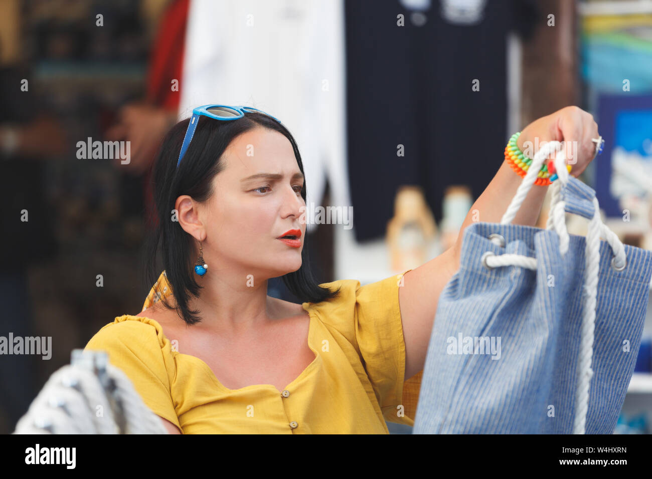 Donna scegliendo e shopping borsa da spiaggia in outdoor market shop store, il fuoco selettivo Foto Stock