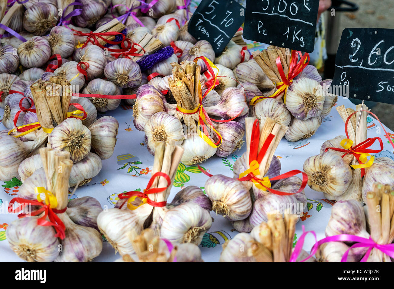Un mercato in stallo Lavardac, in Francia, in Europa la vendita di bellissimi mazzetti di aglio fresco lampadine legati insieme con nastri Foto Stock