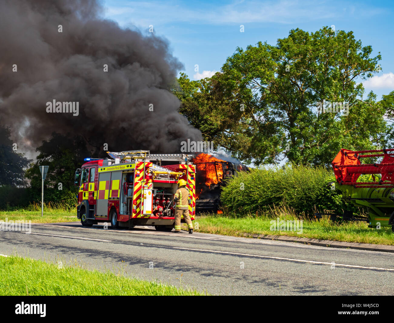 Un equipaggio da Lincolnshire fuoco e di salvataggio Indossare respiratore in azione sulla scena di un importante veicolo incendio che coinvolgesse una mietitrebbia Foto Stock